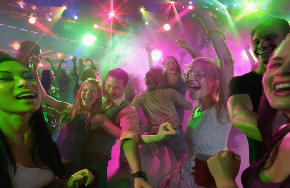 Young people dancing and having fun in a large nightclub.