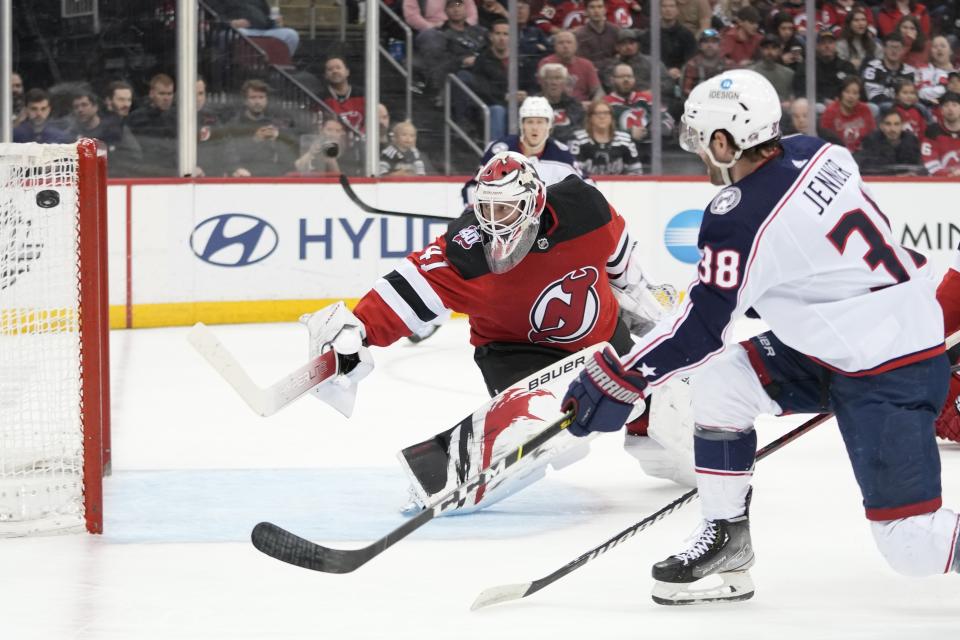 New Jersey Devils goaltender Vitek Vanecek (41) makes a save against against Columbus Blue Jackets center Boone Jenner (38) during the first period of an NHL hockey game Thursday, April 6, 2023, in Newark, N.J. (AP Photo/Mary Altaffer)