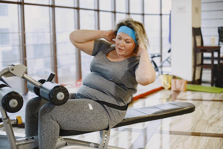 Woman doing sit ups in a gym.