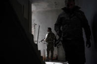 U.S.-backed Syrian Democratic Forces (SDF) fighters walk in a building as fight against Islamic State militants continue in the village of Baghouz, Syria, Saturday, Feb. 16, 2019. (AP Photo/Felipe Dana)