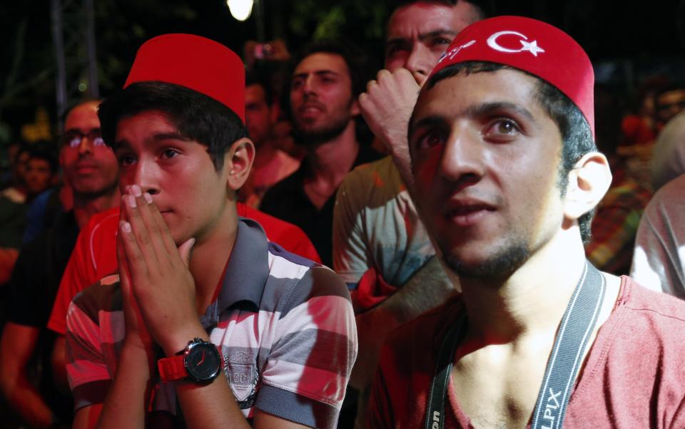 Turks react after finding out that Tokyo was awarded the right to host the 2020 Summer Games as they watch it live on big screens in Sultanahmet Square in Istanbul