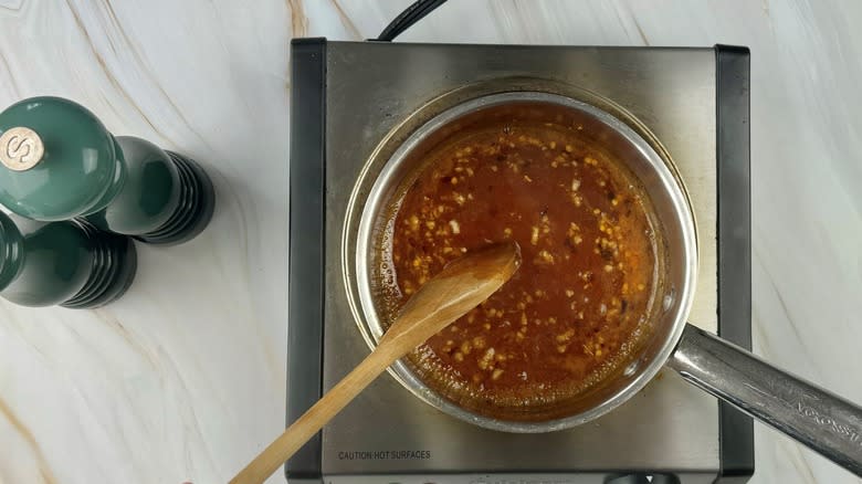 spoon stirring liquid in pan
