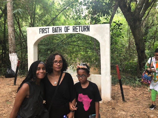 Dr. Lesley Hanes stands outside the Assin Manso Last Bath Slave River with her daughters, Jasmine, 14, (left) and Maya, 10. The river is where captured Africans were taken for their last bath before being shipped to the western world.