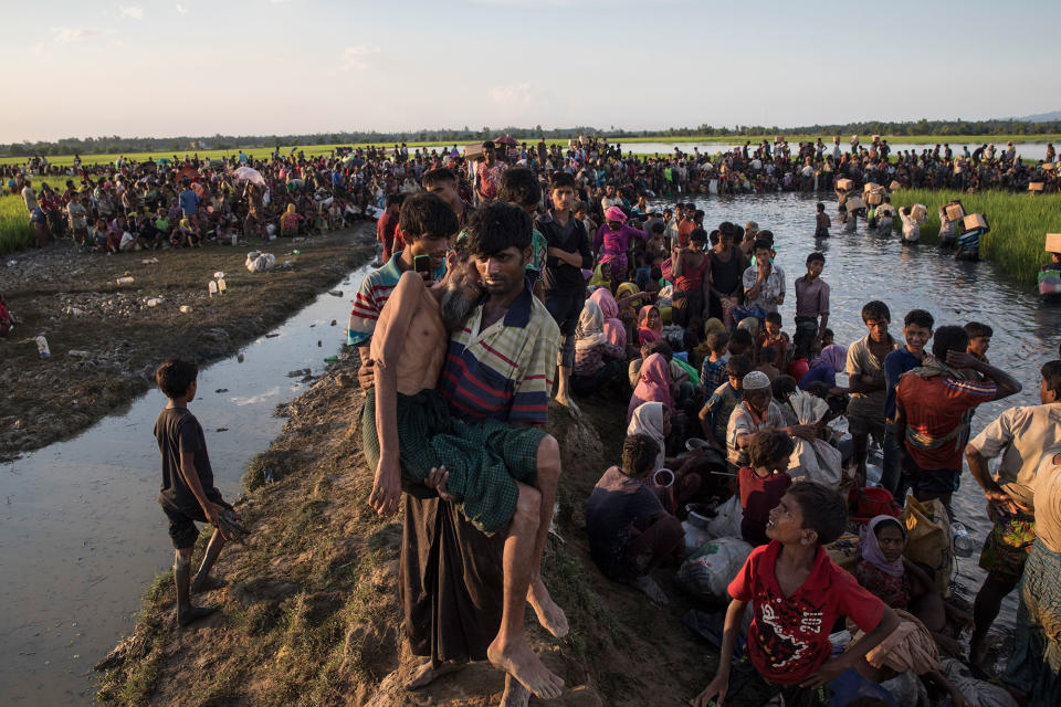 <p>An elderly man who collapsed is carried to a medical facility as thousands of Rohingya refugees fleeing from Myanmar sit along a muddy rice field after crossing the border near Palang Khali, Cox’s Bazar, Bangladesh, on October 16, 2017. (Photograph by Paula Bronstein/Getty Images) </p>