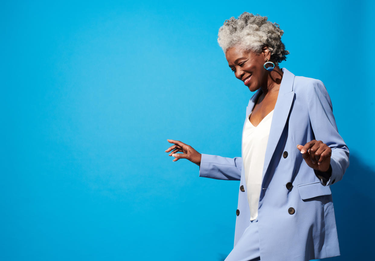 Close-up portrait of a beautiful senior woman against blue background