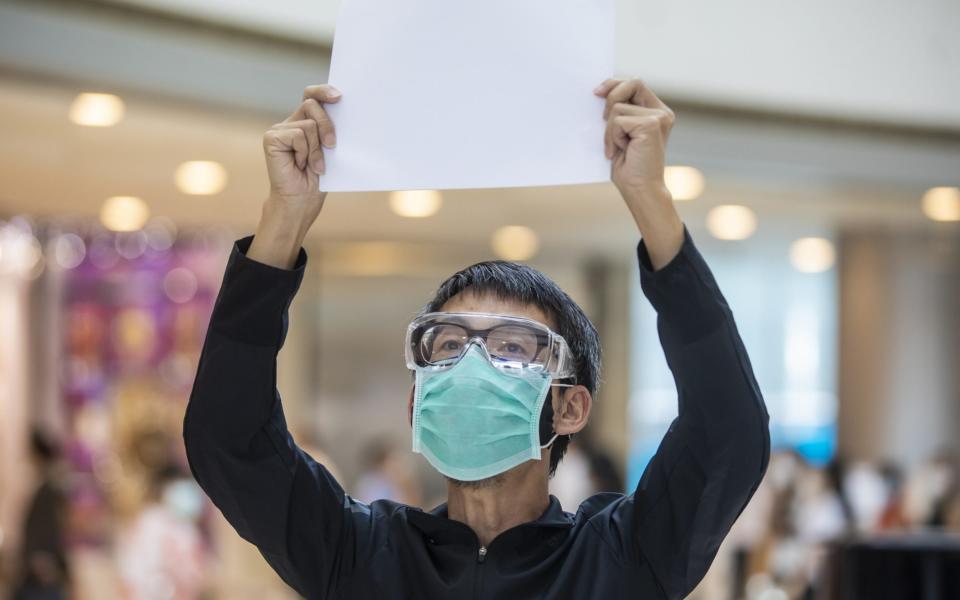 A protester holds up a blank sheet of paper after the introduction of a crackdown on freedom of speech - Bloomberg