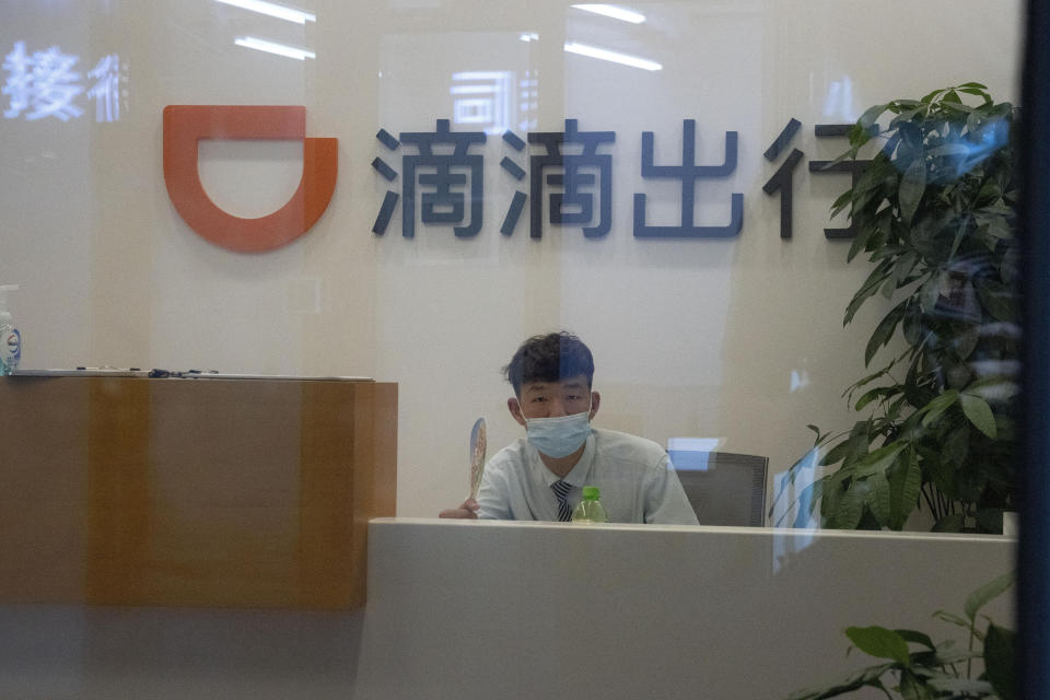 FILE - In this July 16, 2021, file photo, a receptionist looks up from an office for drivers of Didi in Beijing. Foreign shareholders in China's tech companies are learning what its entrepreneurs have long known: The ruling Communist Party's decisions about what is good for the economy can hurt your business. (AP Photo/Ng Han Guan, File)