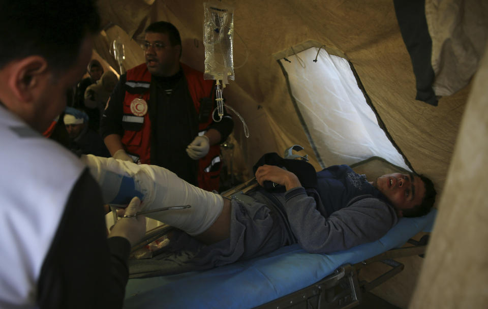 Medics treat youth protester in a field clinic tent after he was shot during a protest near the fence of the Gaza Strip border with Israel, near Beit Lahiya, northern Gaza Strip, Tuesday, Feb. 19, 2019. (AP Photo/Adel Hana)