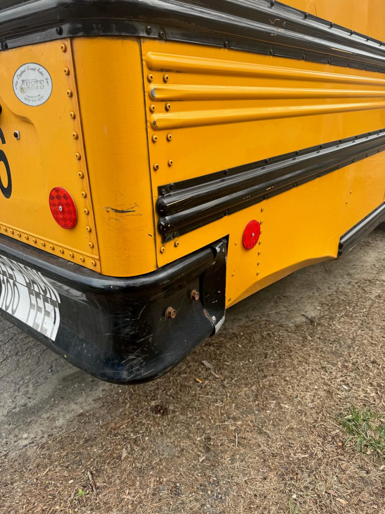 Millis police say this bus was damaged after its driver struck trash barrels while attempting a three-point turn on Village Street.