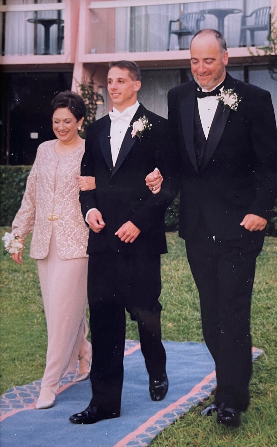 Andrew Ladores walks down the aisle at his wedding with his mother and Bill Plaschke.