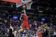 New Orleans Pelicans forward Zion Williamson, second from left, dunks against Phoenix Suns guard Devin Booker, left, in the second half of an NBA basketball game in New Orleans, Friday, Dec. 9, 2022. (AP Photo/Matthew Hinton)