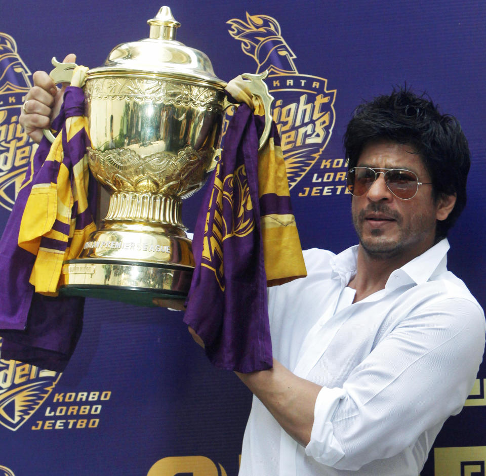 Bollywood actor Shah Rukh Khan displays the Indian Premier League (IPL) cricket trophy during a news conference at his residence in Mumbai May 30, 2012. Khan's Kolkata Knight Riders team won the 2012 IPL after defeating Chennai Super Kings on May 27. REUTERS/Vivek Prakash (INDIA - Tags: SPORT ENTERTAINMENT CRICKET)