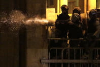 Riot police fire rubber bullets against the anti-government protesters, during ongoing protests against the political elites who have ruled the country for decades, in Beirut, Lebanon, Sunday, Jan. 19, 2020. Lebanese security forces used tear gas, water cannons and rubber bullets in clashes with hundreds of anti-government protesters outside the country's Parliament on Sunday, as violence continued to escalate in a week of rioting in the capital. (AP Photo/Hassan Ammar)