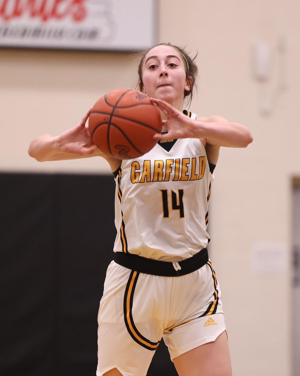 Garfield senior forward Madeline Shirkey fires a pass to a teammate during Thursday night's basketball game against the Liberty Leopards at James A. Garfield High School.