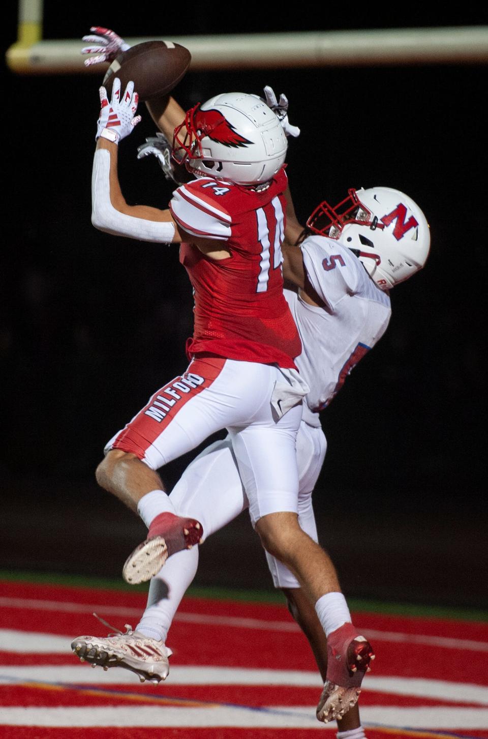 Milford High School's CJ Ferrell, #14, breaks up a potential touchdown pass to Natick captain Arnold Kawere. Later Farrell left the game with an injury. Milford went on to win, 7-0, Sept. 22, 2023.