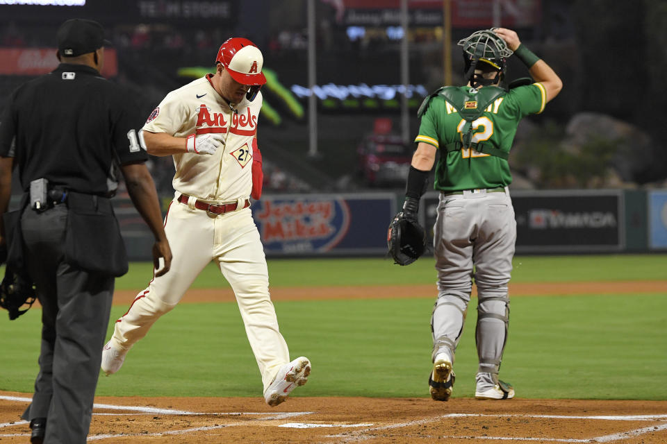 Los Angeles Angels' Mike Trout, center, scores on a single by Shohei Ohtani as Oakland Athletics catcher Sean Murphy, right, stands by during the first inning of a baseball game Thursday, Sept. 29, 2022, in Anaheim, Calif. (AP Photo/Mark J. Terrill)