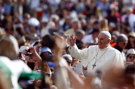 Pope Francis waves as he arrives to lead his weekly general audience in Saint Peter's Square at the Vatican October 1, 2014. REUTERS/Tony Gentile