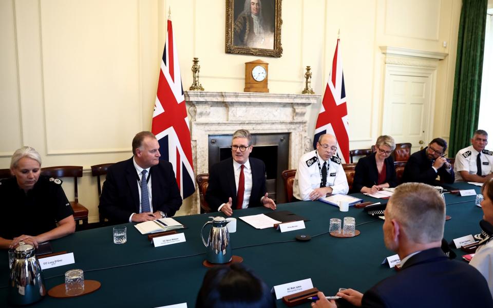 Prime Minister Keir Starmer (C) holds a meeting to discuss the clashes that followed the stabbing in Southport