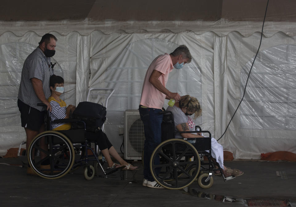 Patients wait to be attended to at the Steve Biko Academic Hospital's outside parking area in Pretoria, South Africa, Monday, Jan. 11, 2021. As the numbers of new confirmed cases rise, South Africa's hospitals are exceeding capacity, according to health officials. (AP Photo/Denis Farrell)