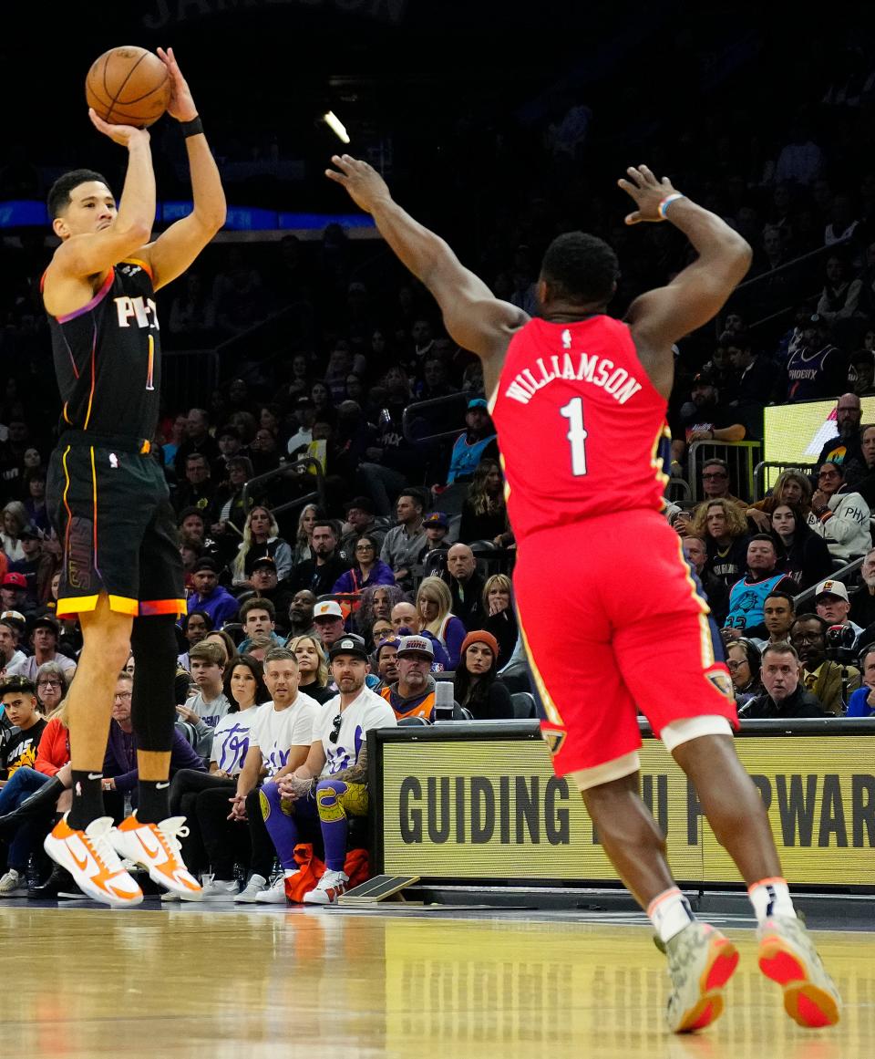 December 17, 2022; Phoenix, Ariz; USA; Suns guard Devin Booker (1) scores against Pelicans Zion Williamson (1) during the first half at the Footprint Center. 