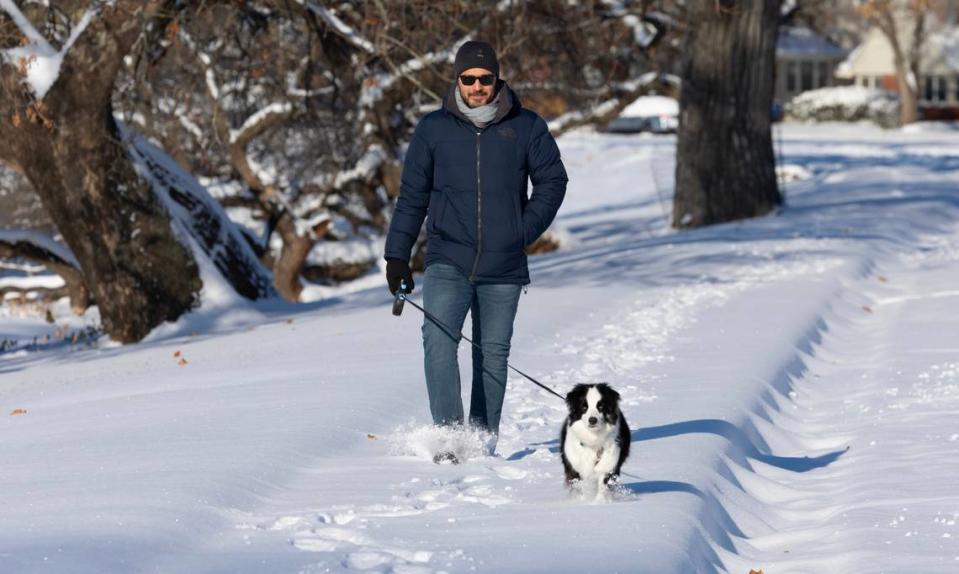 Farshad Houtaham walks his dog Eli through the snow along Stackman Drive on Sunday, the morning after 7.8 inches of snow fell in the Wichita area. 