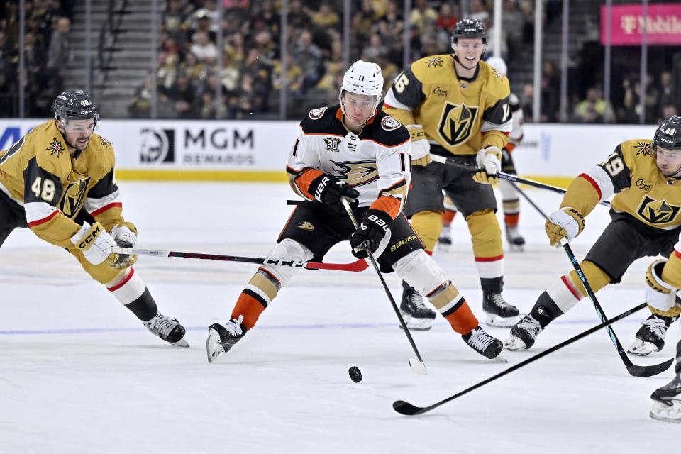 Anaheim Ducks center Trevor Zegras (11) skates with the puck between Vegas Golden Knights center Tomas Hertl (48), left wing Pavel Dorofeyev (16) and center Ivan Barbashev (49) during the first period of an NHL hockey game Thursday, April 18, 2024, in Las Vegas. (AP Photo/David Becker)