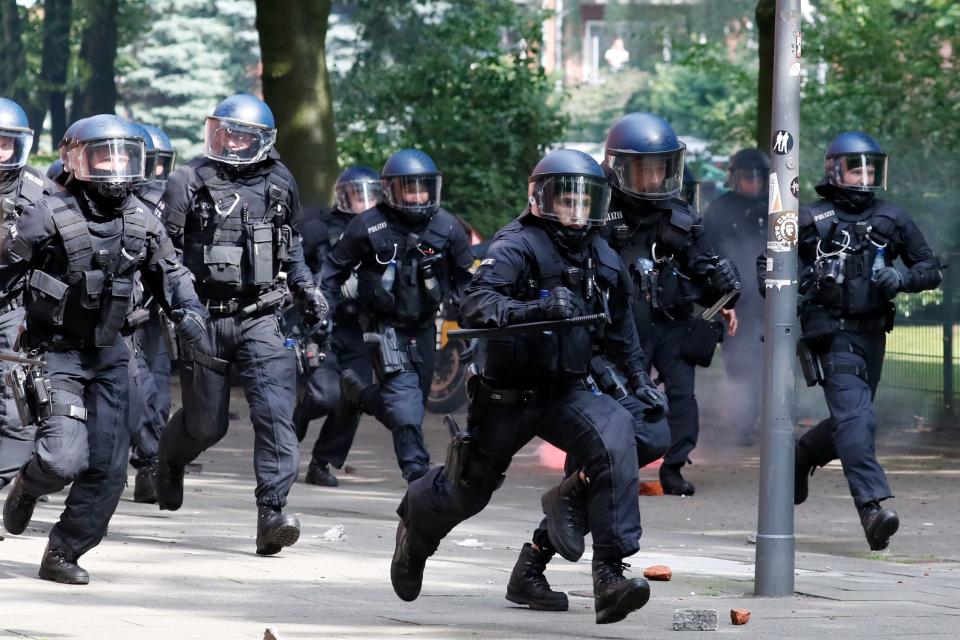 Riot police chase protesters.&nbsp;