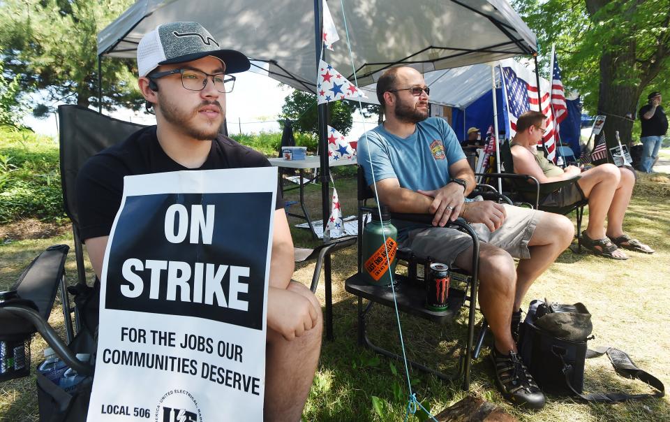 Andy Doutt, 22, left, and Brian Wurst, 42, members of the United Electrical, Radio and Machine Workers of America, man a picket line at the Wabtec Corp. Franklin Avenue gate Wednesday. Both men said they were hired on the same day, roughly nine months ago.