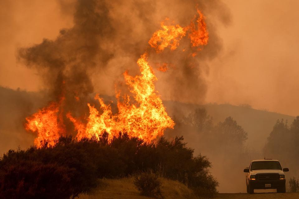 Flames leap above a vehicle on High Valley Road as the Ranch fire, part of the Mendocino Complex fire, burns near Clearlake Oaks, California, on Sunday. (Photo: NOAH BERGER via Getty Images)