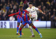 Crystal Palace's Wilfried Zaha, left, and Leeds United's Robin Koch battle for the ball during the English Premier League soccer match between Crystal Palace and Leeds United at Selhurst Park, London, Monday April 25, 2022. (John Walton/PA via AP)