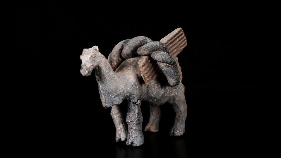 A camel or horse figurine against a black background.