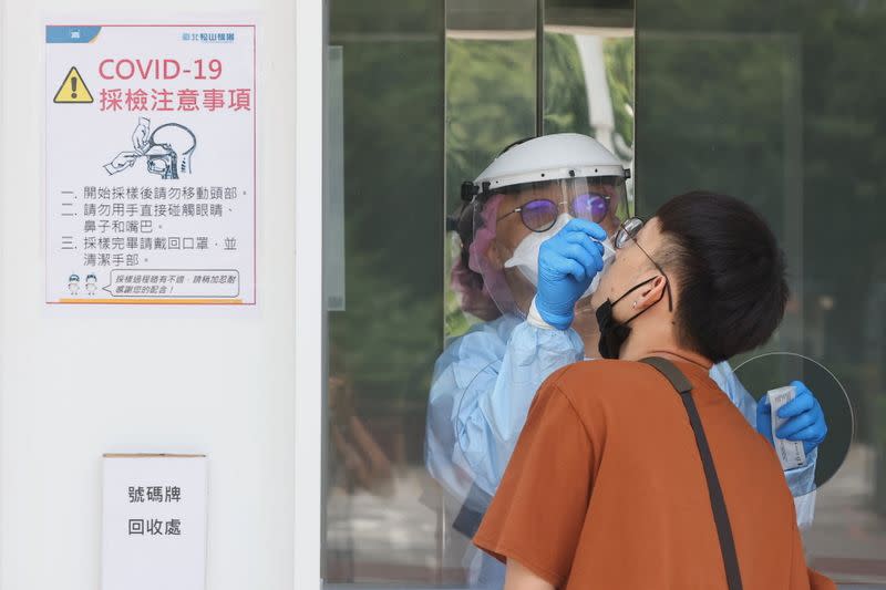 A medical worker conducts a rapid test for coronavirus disease in Taipei