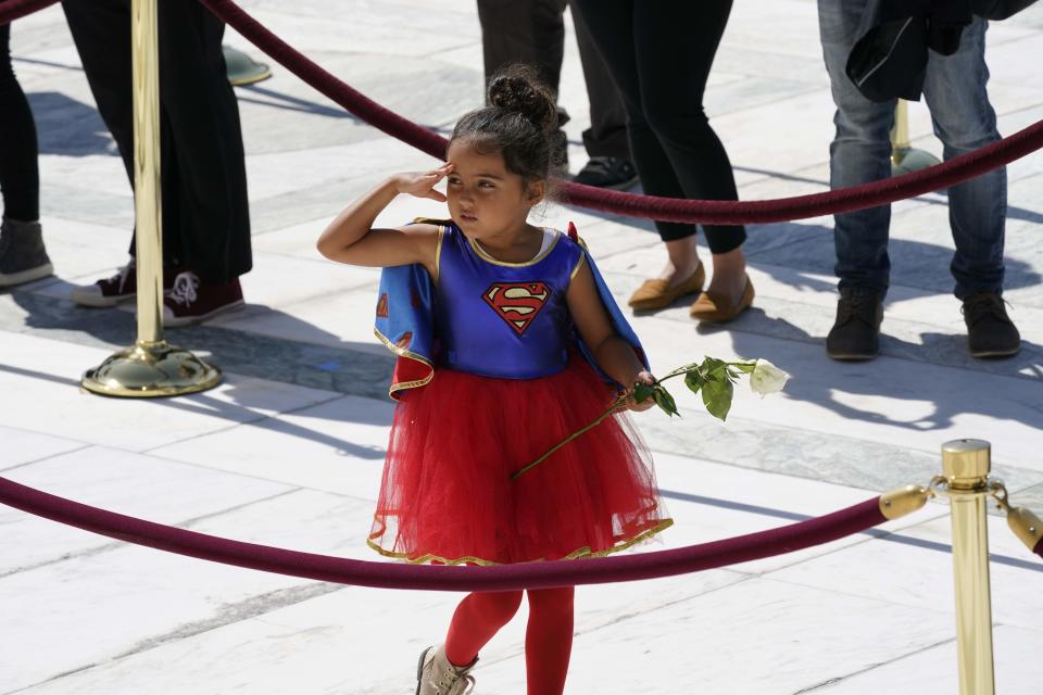 A child in a Supergirl costume pays respects as Associate Justice Ruth Bader Ginsburg lies in repose in front of the U.S. Supreme Court in Washington, D.C., on Sept. 23.