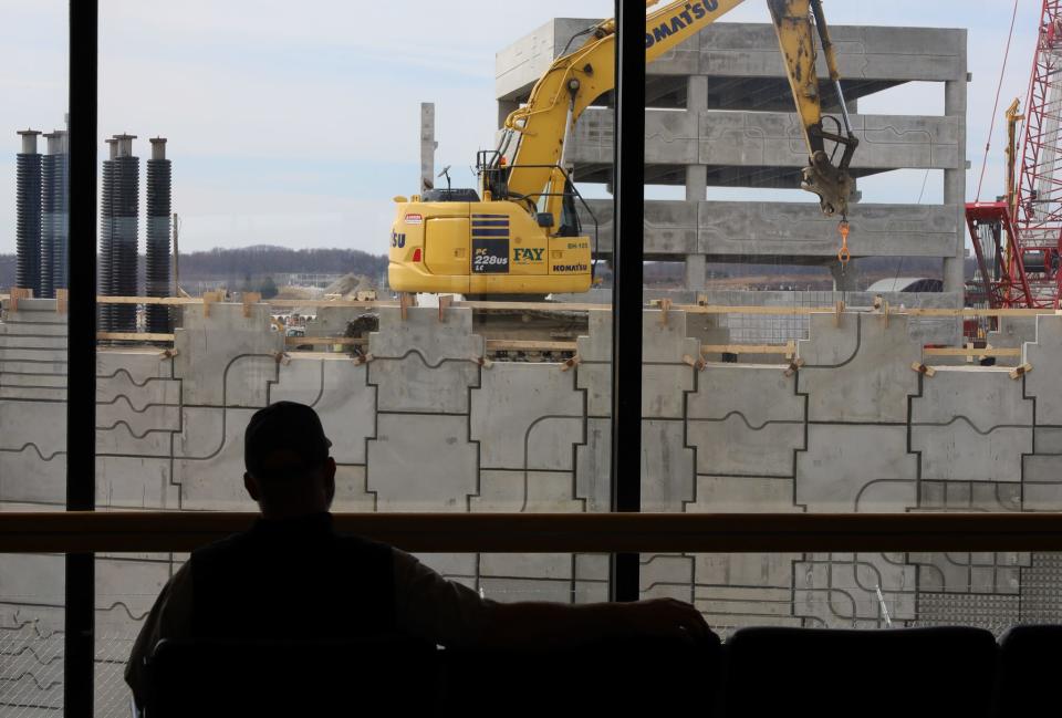 A traveler at the Pittsburgh International Airport (PIT) watches the construction outside Concourse D as he waits for a flight on March 9, 2023. The area outside will be a part of the renovated parking at the popular airport.
