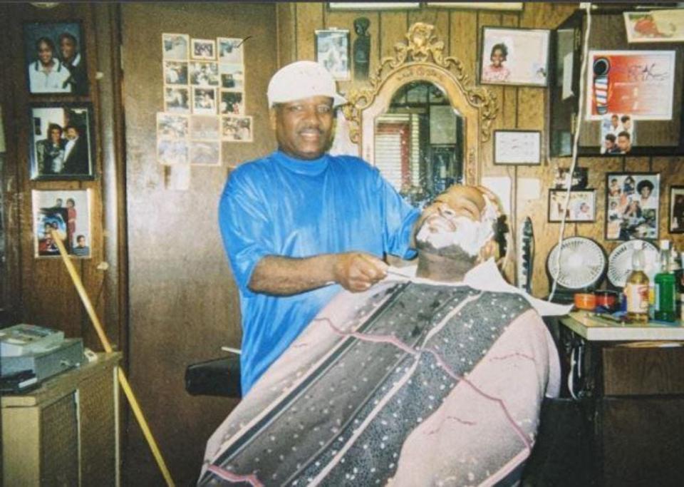 Harlan Thomas shaves a customer in this undated photo from the application to make Harlan's Barber Shop, 2513 Woodland Ave., a Des Moines city landmark.