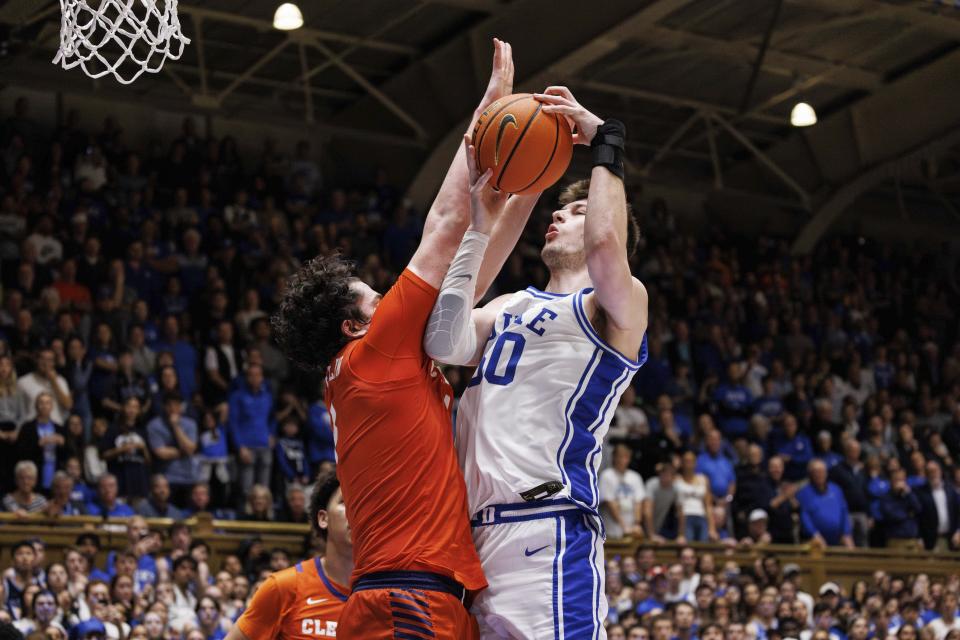 Duke's Kyle Filipowski, right, is fouled by Clemson's Ian Schieffelin, front left, late in the second half of an NCAA college basketball game in Durham, N.C., Saturday, Jan. 27, 2024. (AP Photo/Ben McKeown)