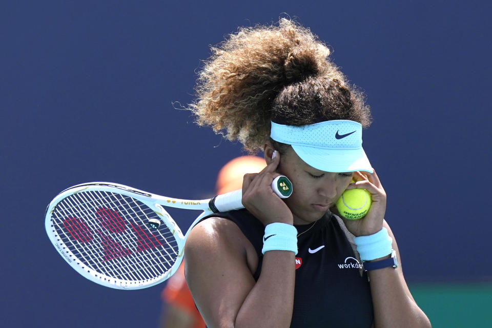 Naomi Osaka se tapa los oídos durante el duelo contra Maria Sakkari en los cuartos de final del Abierto de Miami, el miércoles 21 de marzo de 2021. (AP Foto/Lynne Sladky)