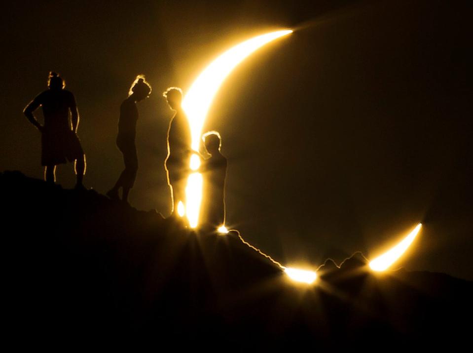Hikers watch a partial solar eclipse from Papago Park in Phoenix on May 20, 2012.