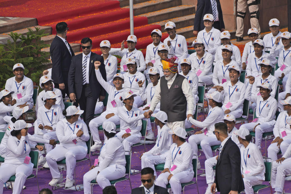 Indian Prime Minister Narendra Modi shakes hands with children after delivering his speech at 17th century Mughal-era Red Fort monument on country's Independence Day in New Delhi, India, Tuesday, Aug.15, 2023. Modi promised to take India's economy into the top three in the world in the next five years, as he marked 76 years of independence from British rule on Tuesday. (AP Photo/Manish Swarup)