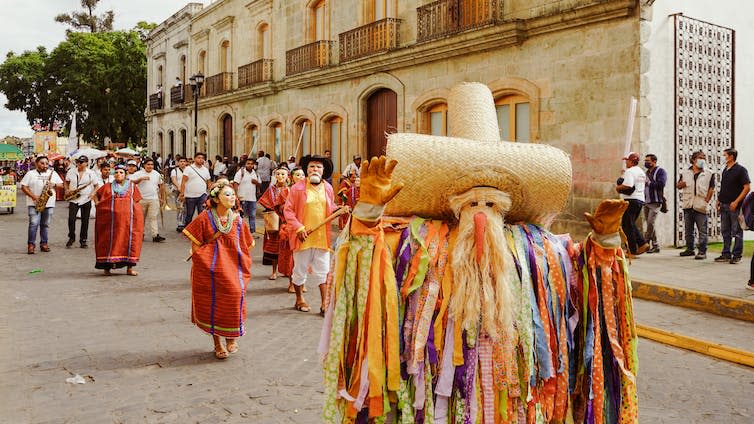 Man in a traditional parade costume with musicians.