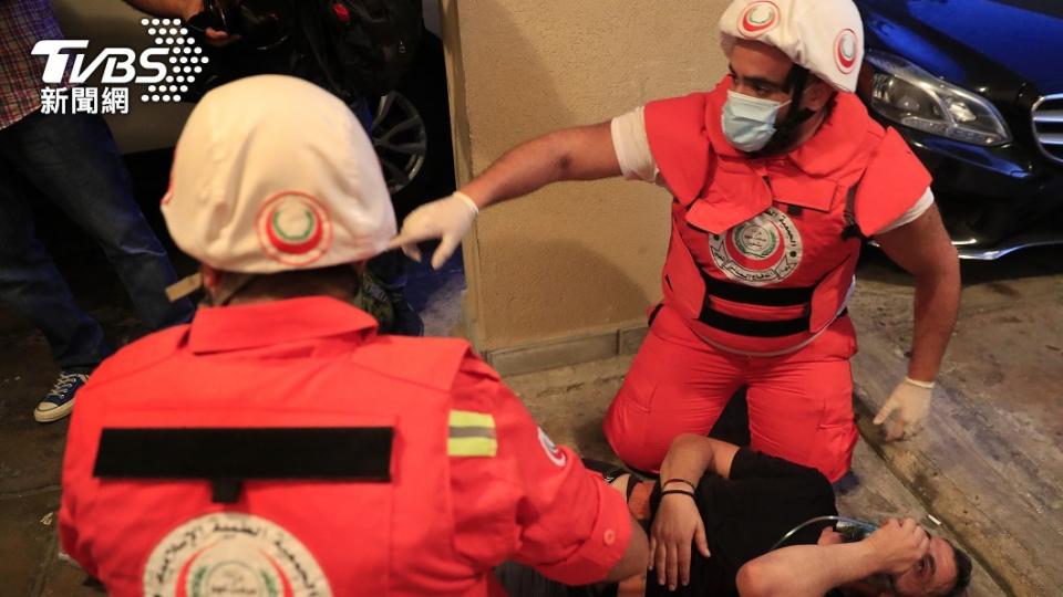 圖／達志影像美聯社，一位抗議者因為吸入催淚瓦斯倒地，被救護人員抬上擔架送醫治療。