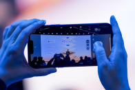 A person takes a cellphone video as Microsoft CEO Satya Nadella speaks during a showcase event of the company's AI assistant, Copilot, ahead of the annual Build developer conference at Microsoft headquarters, Monday, May 20, 2024, in Redmond, Wash. (AP Photo/Lindsey Wasson)