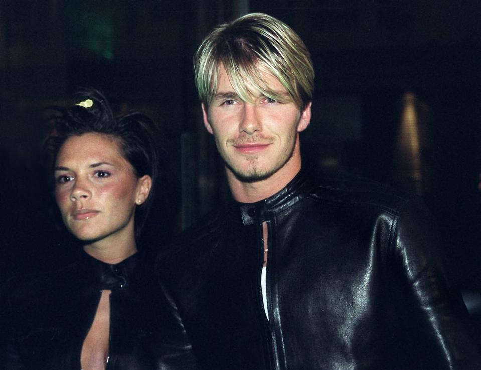 Victoria and David Beckham in matching leather pantsuits to a Versace party in 1999 (AFP via Getty Images)