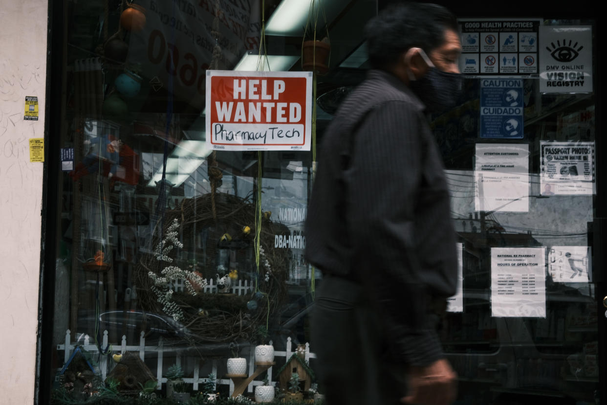 People walk by a Help Wanted sign in New York City on June 04, 2021 as the U.S. economy added 559,000 jobs in May, bringing the unemployment rate down to 5.8% from 6.1%. (Photo by Spencer Platt/Getty Images)