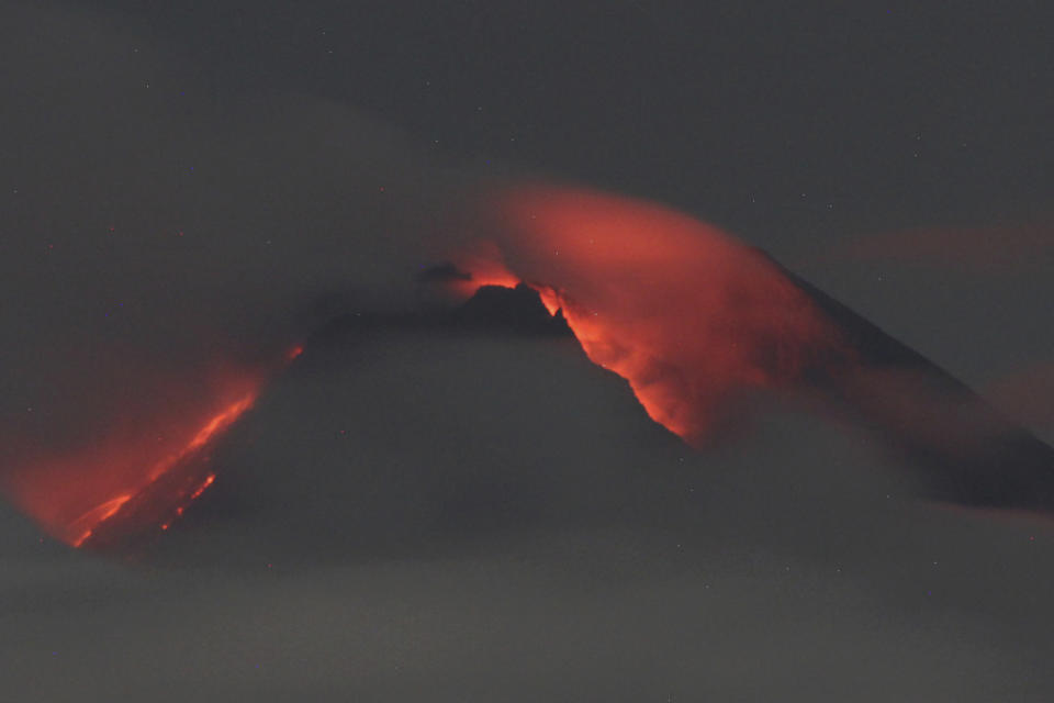 Lava flows down from the crater of Mount Merapi seen from Pakembinangun village in Sleman, Central Java, Thursday, March 10, 2022. Indonesia's Mount Merapi volcano spewed avalanches of hot clouds in eruptions overnight Thursday that forced about 250 residents to flee to temporary shelters. No casualties were reported. (AP Photo/Ranto Kresek)