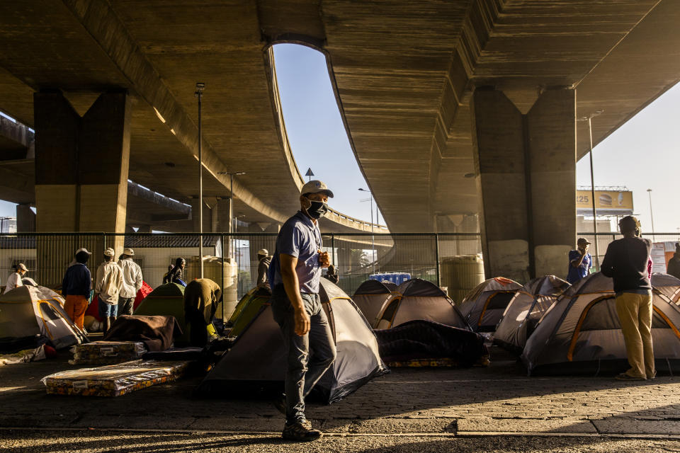 Homeless people living in tents under a bridge in Cape Town, South Africa, Friday, May 22, 2020, after being transported from a closed shelter to another unfinished shelter. (AP Photo)