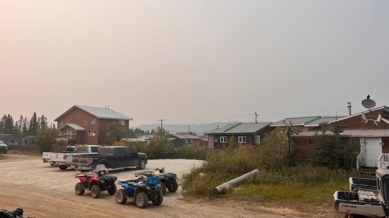 A smoky haze blankets Old Crow, Yukon, on Wednesday. Residents report that at times, the smoke has been so thick that they can't see across the river. More than a hundred residents have left the community, while some have chosen to stay behind. (Submitted by Gyde Shepherd - image credit)