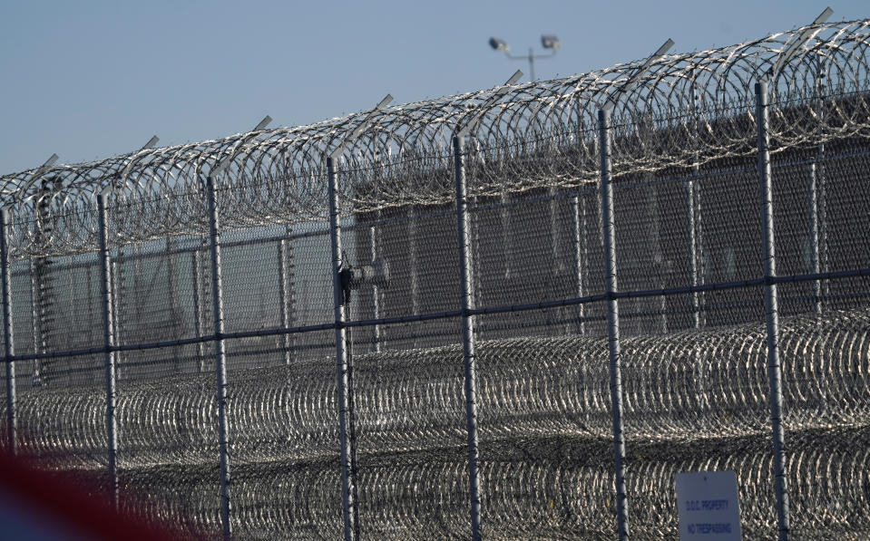 Fencing surrounds the Denver Reception and Diagnostic Center operated by the Colorado Department of Corrections, Tuesday, Dec. 8, 2020, in east Denver. Amber Johnson of Fayetteville, Ark., is fighting to get COVID-19 vaccinations for her 63-year-old father, Ronald Johnson, and his fellow inmates in the facility. (AP Photo/David Zalubowski)