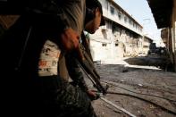 Iraqi Federal Police takes cover as he gets to the frontline at Bab al Jadid district as the battle against Islamic State's fighters continues in the old city of Mosul, Iraq, March 26, 2017. REUTERS/Youssef Boudlal