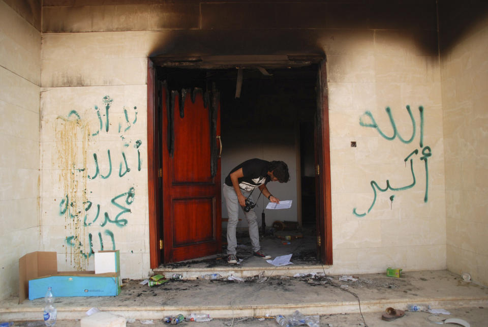 A man looks at documents at the U.S. consulate in Benghazi, Libya, after an attack that killed four Americans, including Ambassador Chris Stevens, Wednesday, Sept. 12, 2012. The graffiti reads, "no God but God," " God is great," and "Muhammad is the Prophet." (AP Photo/Ibrahim Alaguri)